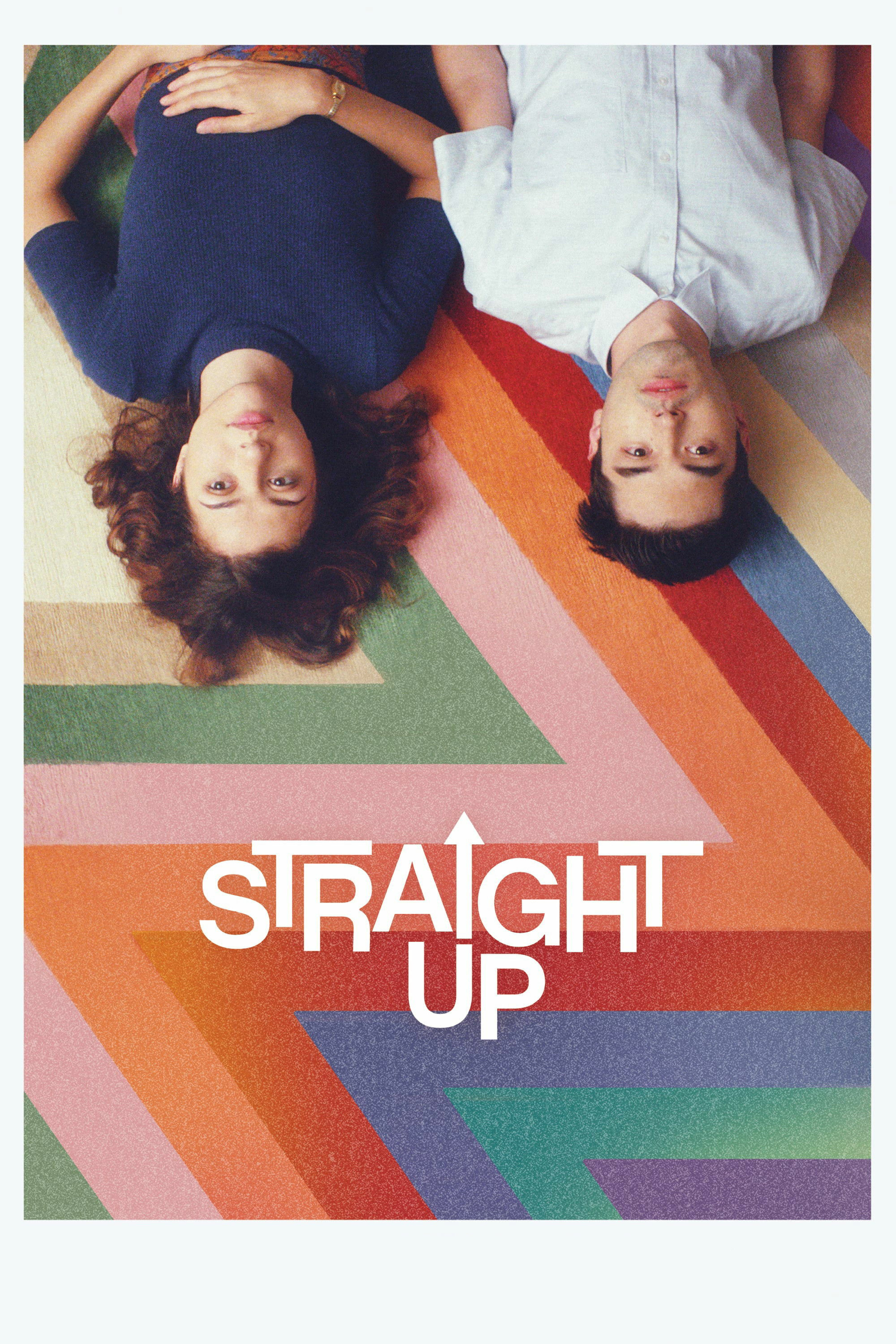 Two individuals are lying upside down on a colorful, geometric patterned surface. The person on the left has medium-length wavy hair and is wearing a dark blue top, while the person on the right has short hair and is wearing a light-colored shirt. The words "STRAIGHT UP" are written in bold white letters with an arrow pointing upwards.